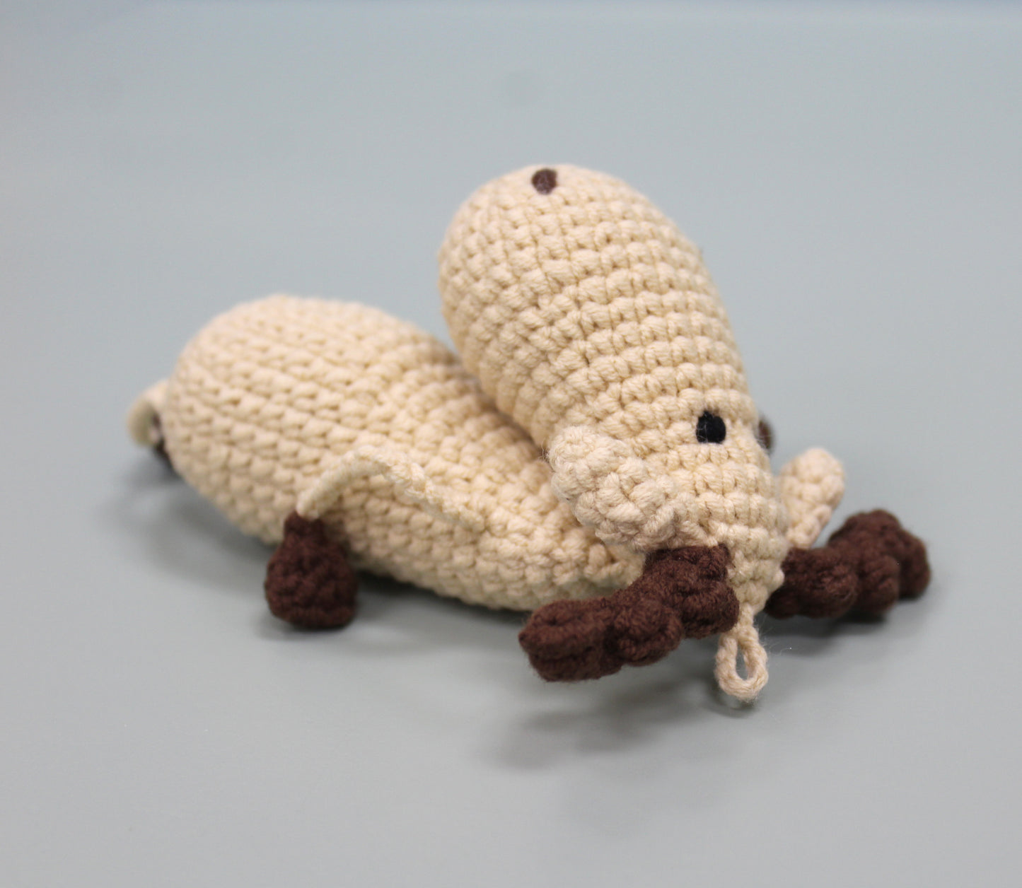 Handmade crochet moose keychain in cream and brown with a loop for hanging.