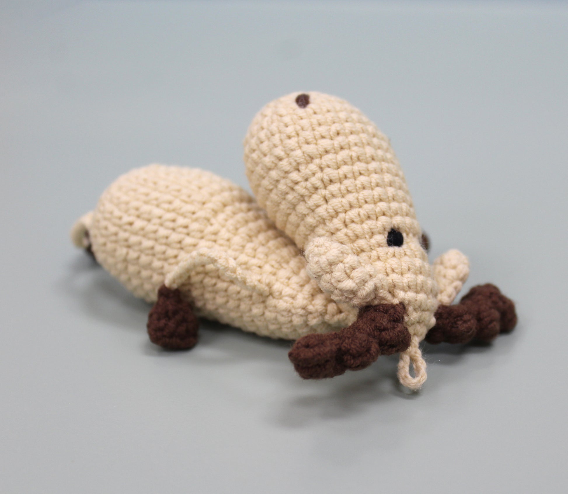 Handmade crochet moose keychain in cream and brown with a loop for hanging.