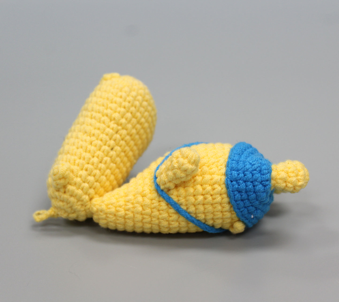 Handmade yellow crochet hippo keychain with blue accents and a blue strap.