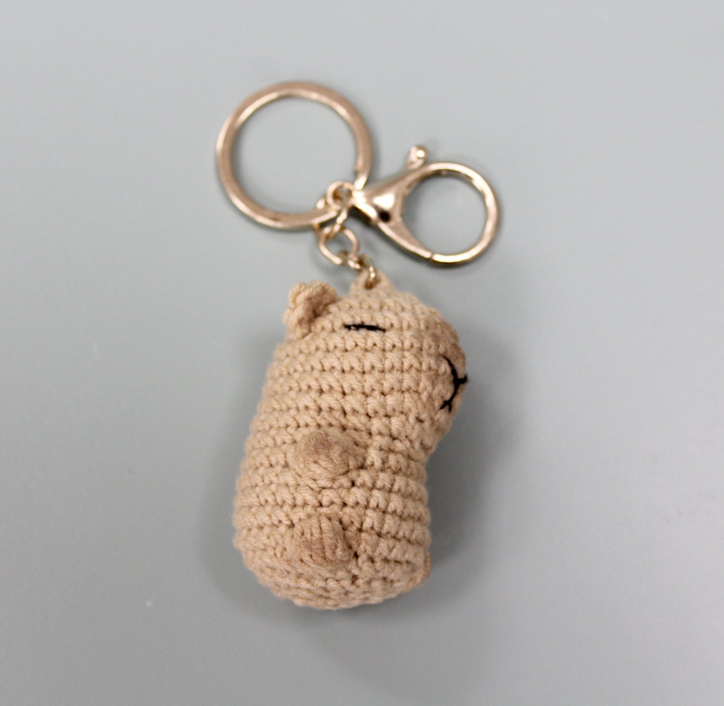 Handmade crochet capybara keychain in beige with a metal ring and clasp.