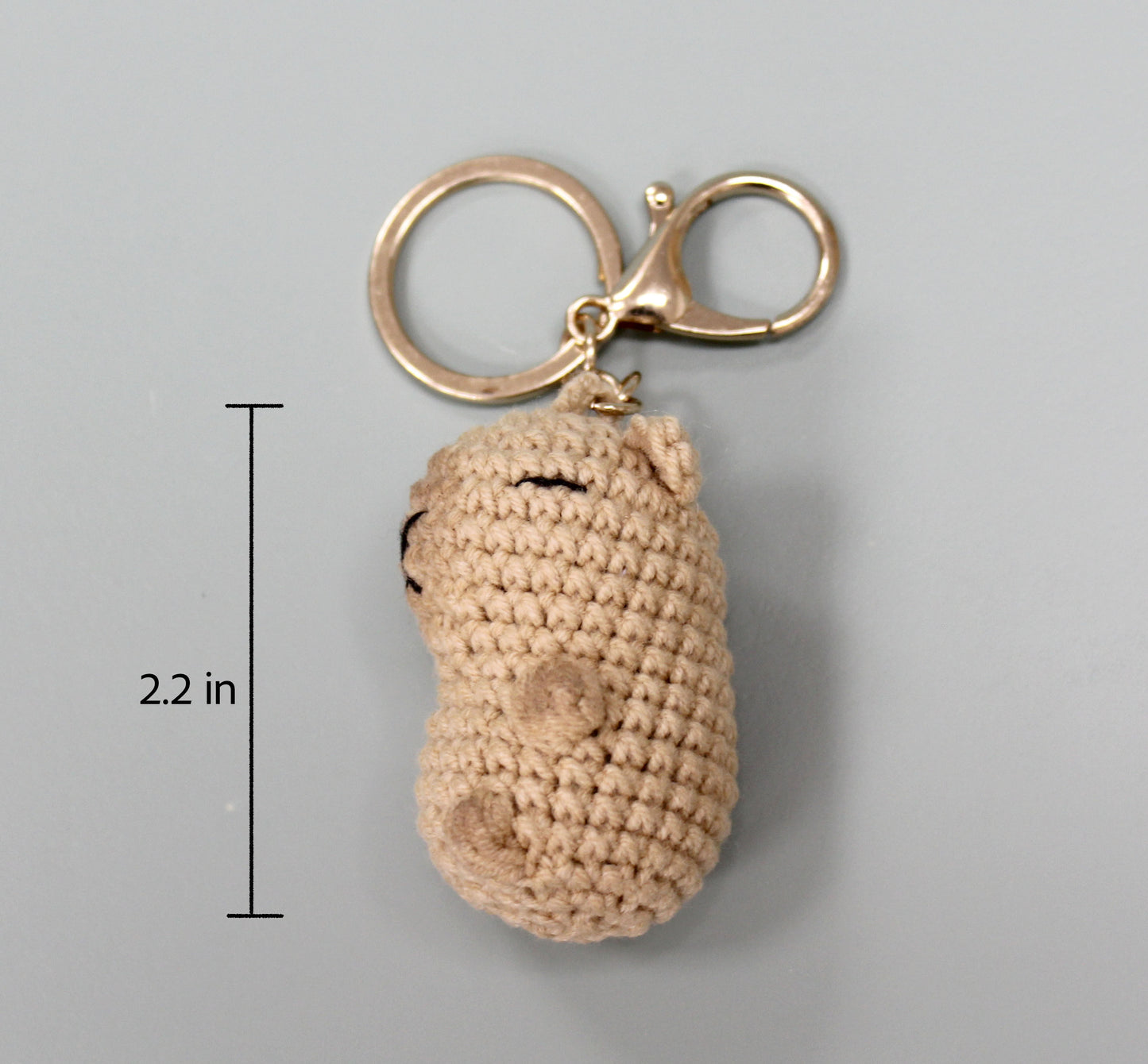 Handmade crochet capybara keychain in beige, featuring a metallic ring and clasp.