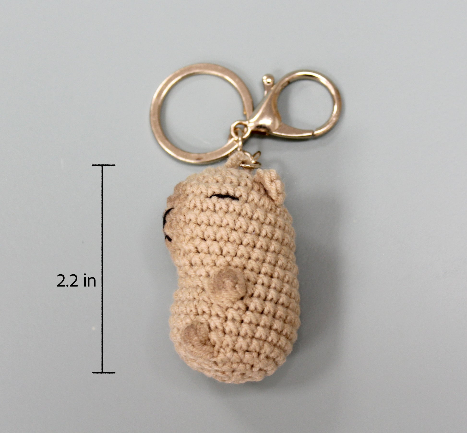 Handmade crochet capybara keychain in beige, featuring a metallic ring and clasp.