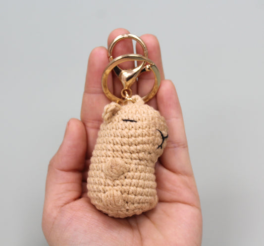 Handmade crochet capybara keychain in beige with a gold-colored metal ring and clasp.
