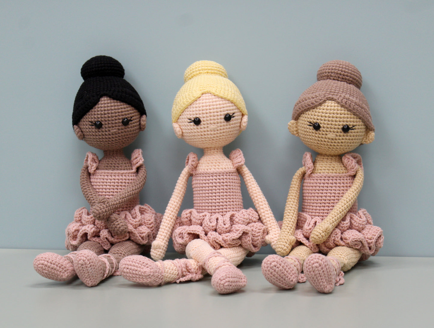 Handmade crochet ballerina dolls in soft pink tones with ruffled skirts and bun hairstyles.