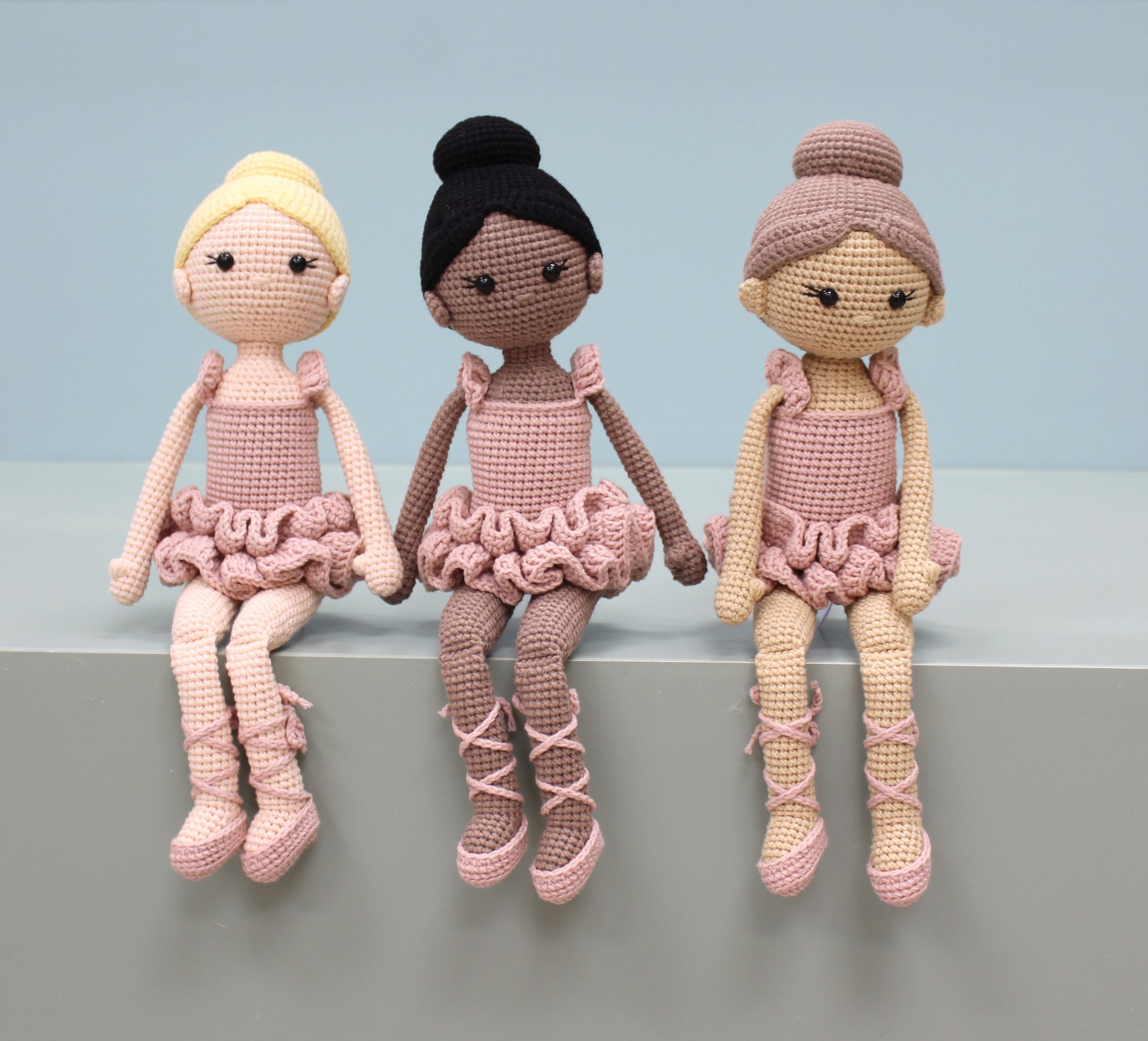 Handmade crochet ballerina dolls in soft pink tones with ruffled skirts and ballet shoes.