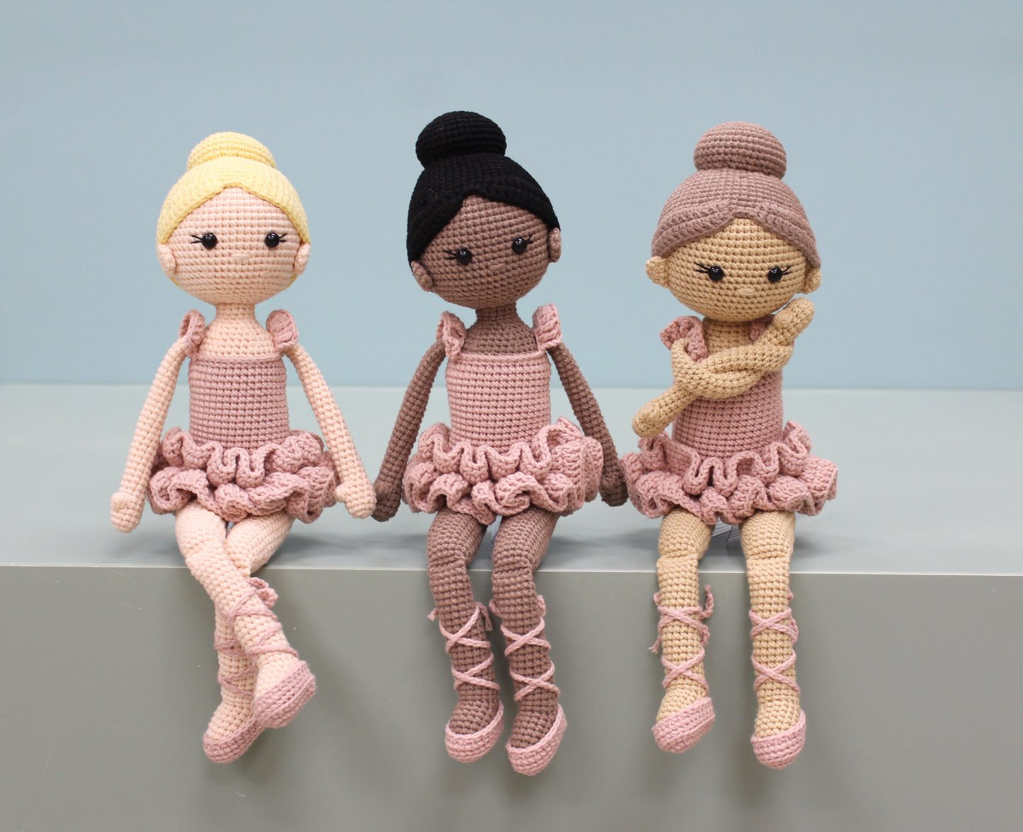 Handmade crochet ballerina dolls in pink tutus with different hair colors and styles.
