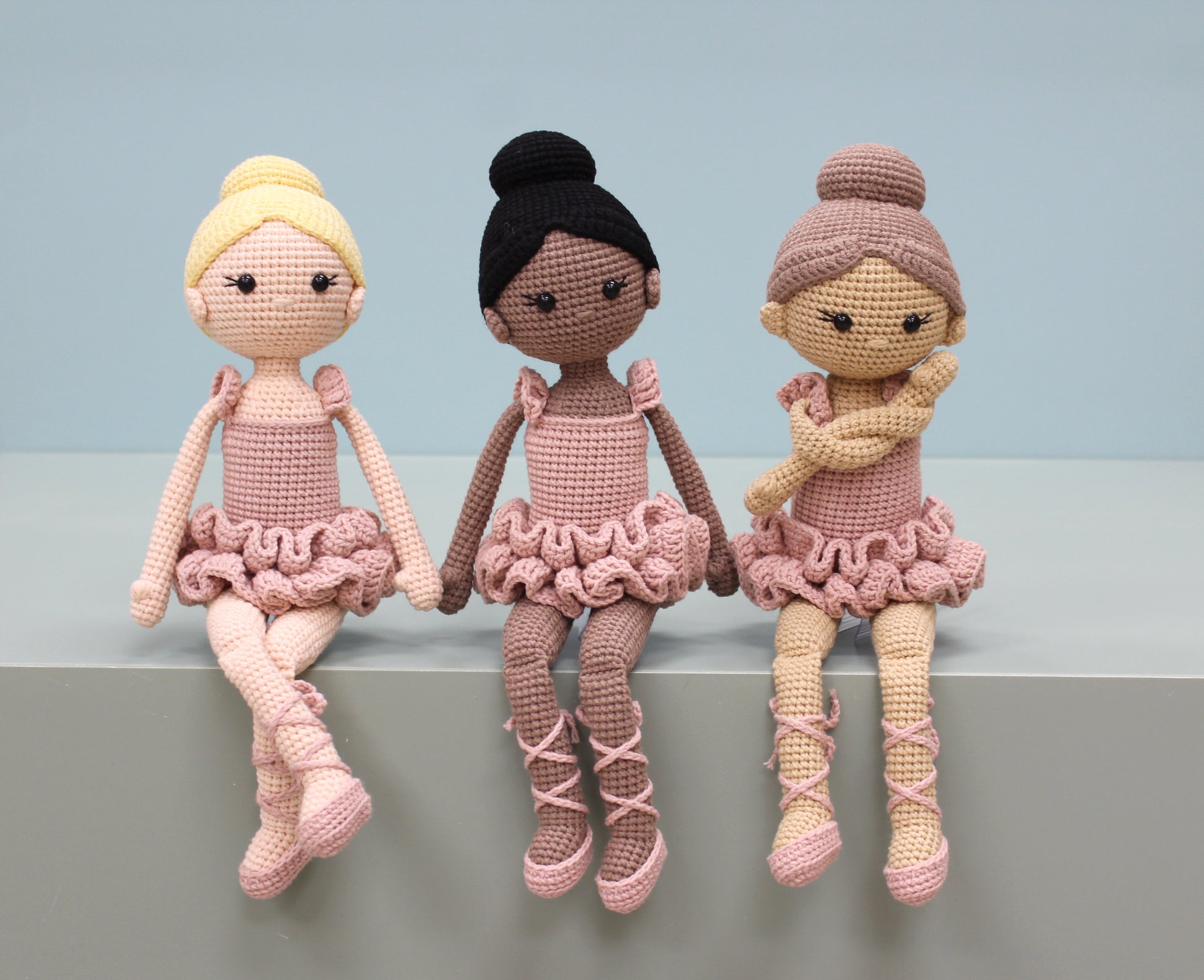 Handmade crochet ballerina dolls in pink tutus with different hair colors and styles.