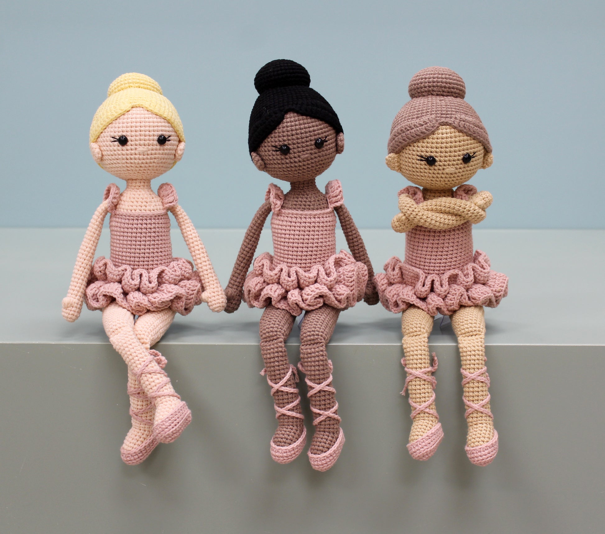 Handmade crochet ballerina dolls in pink hues, featuring ruffled skirts and ballet poses.