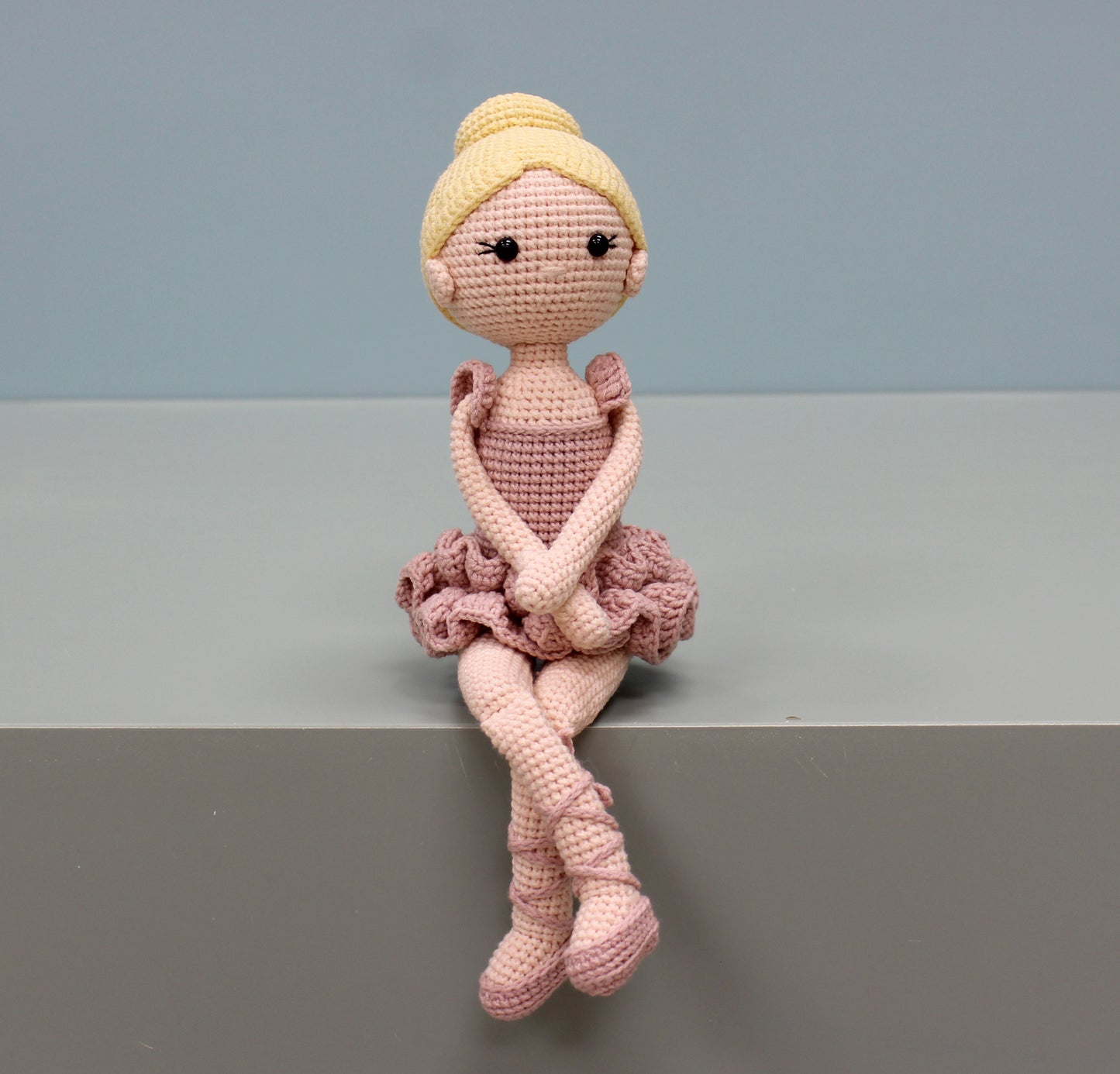 Handmade crochet ballerina doll in pink with a ruffled tutu and yellow bun.