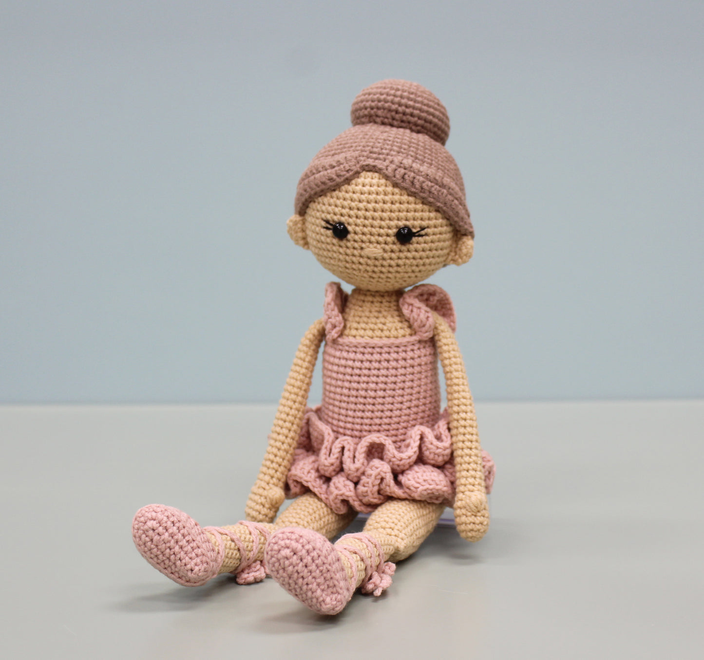 Handmade crochet ballerina doll in soft pink and tan, featuring a ruffled tutu and ballet shoes.