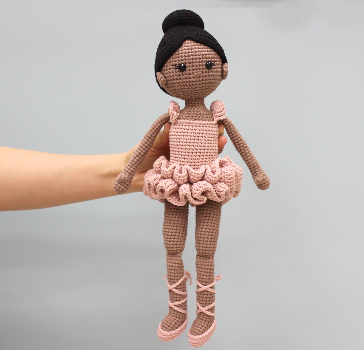 Handmade crochet ballerina doll with brown skin, black hair, and a pink tutu.