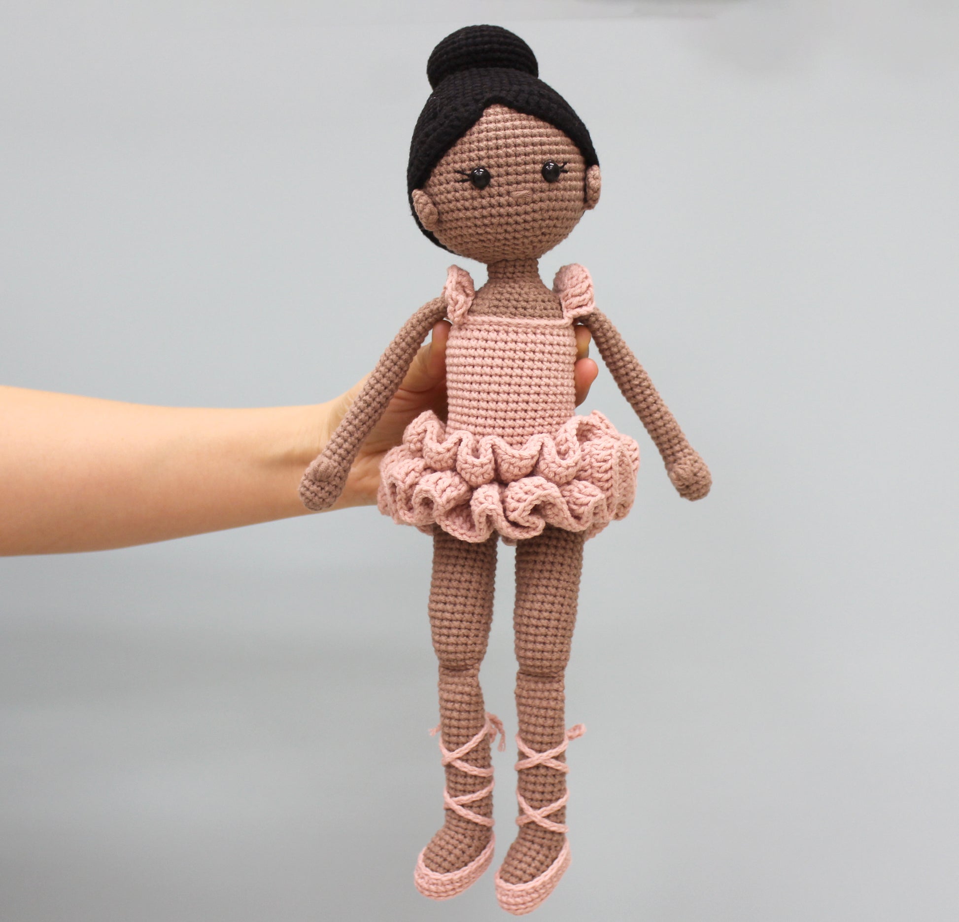 Handmade crochet ballerina doll with brown skin, black hair, and a pink tutu.