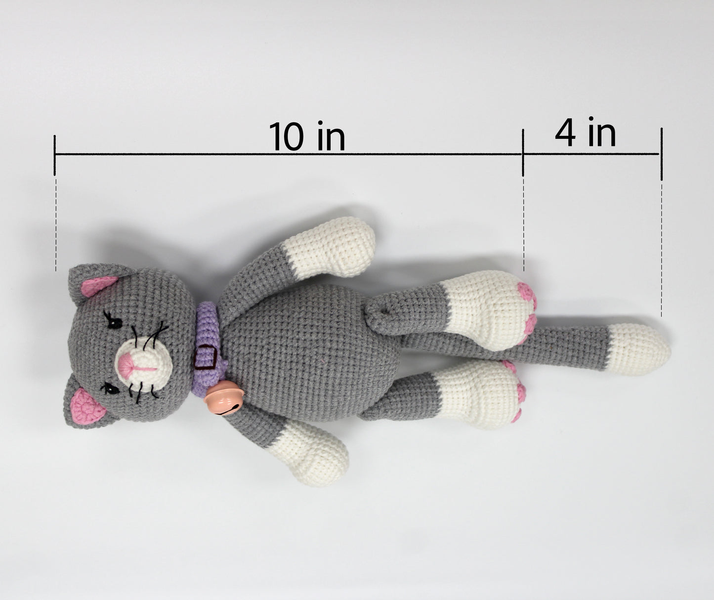Gray and white crochet stuffed cat with pink ears and a purple collar, 10 inches long.