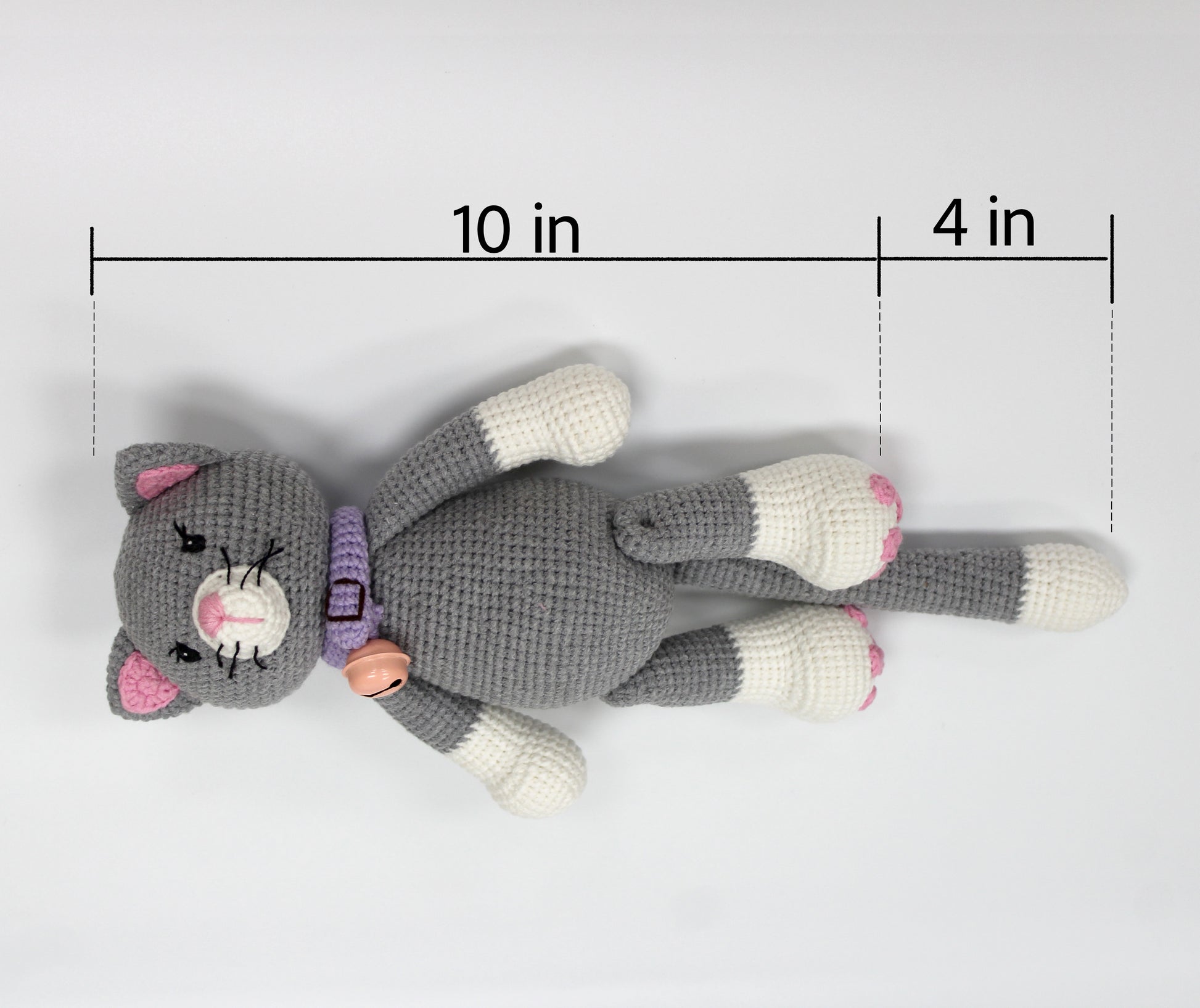 Gray and white crochet stuffed cat with pink ears and a purple collar, 10 inches long.