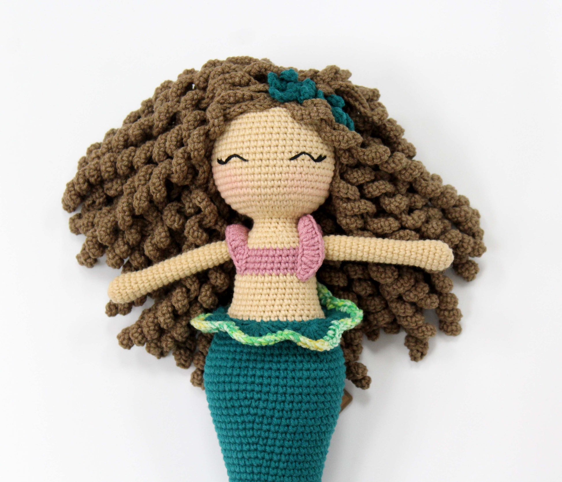 Handmade crochet mermaid doll with brown curly hair, a pink top, and a teal tail.