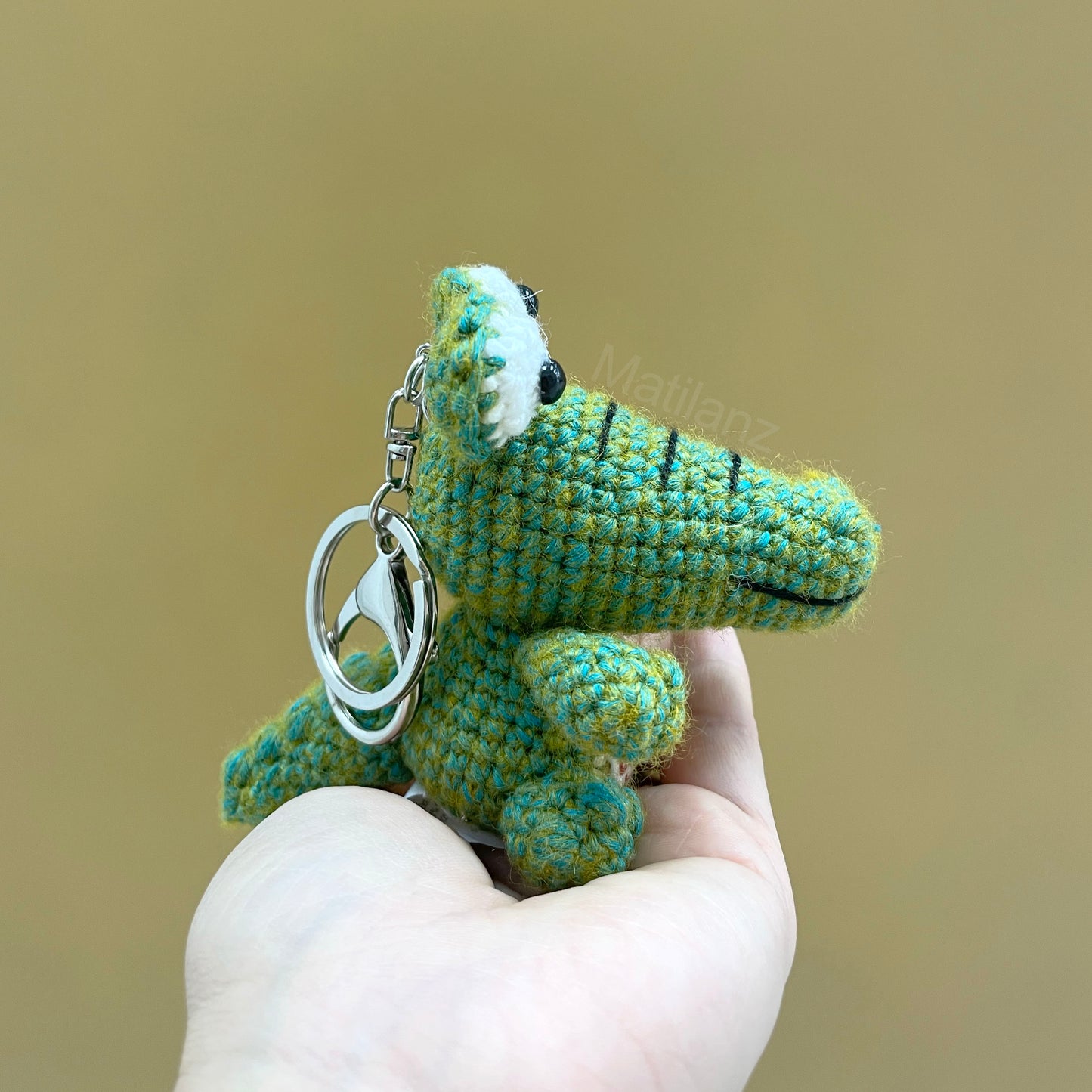 Handcrafted crochet Orlando Gator keychain in greenish-blue with a silver key ring.