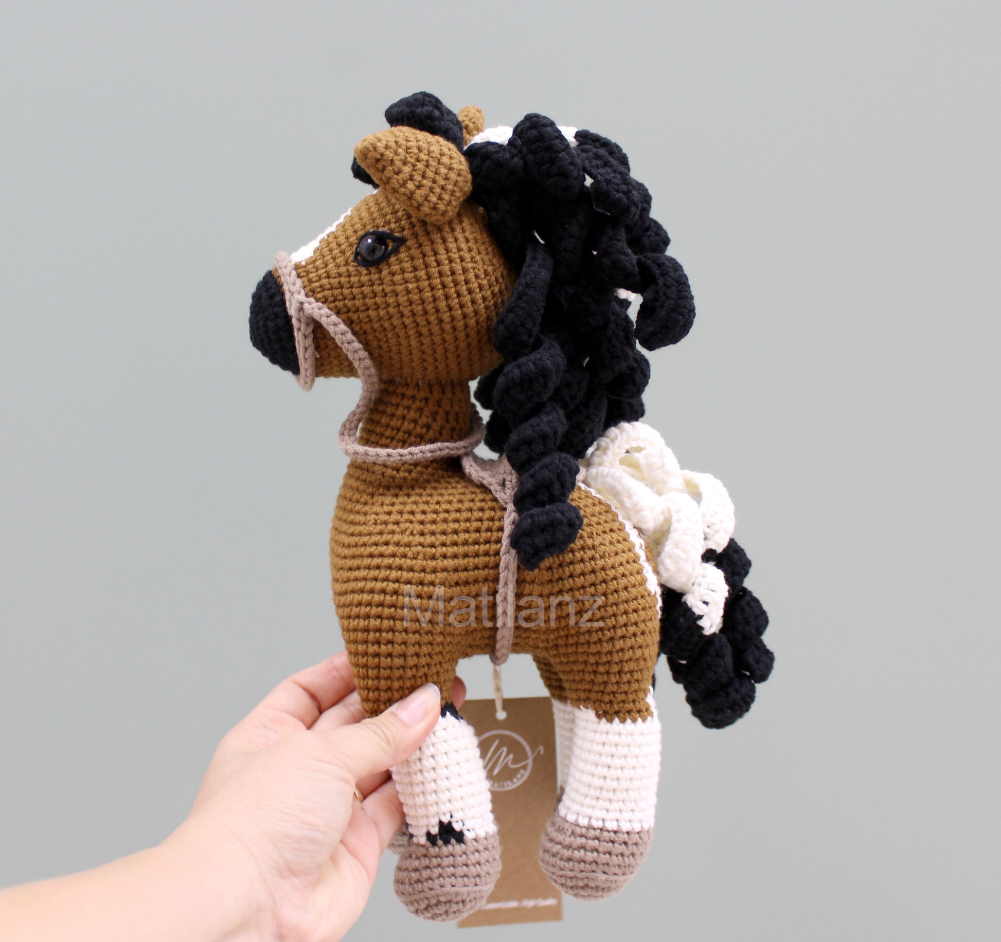 Crochet paint horse plush with brown body, black mane, and white accents, handmade for cozy cuddles.