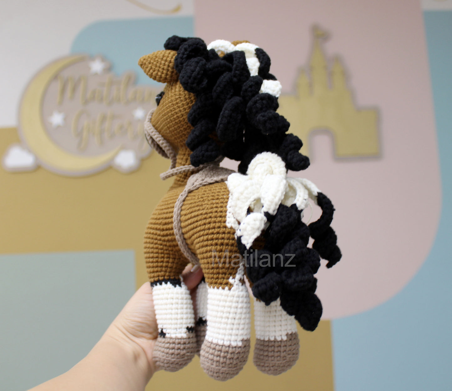 Crochet paint horse plush with brown body, black and white mane, and detailed legs.