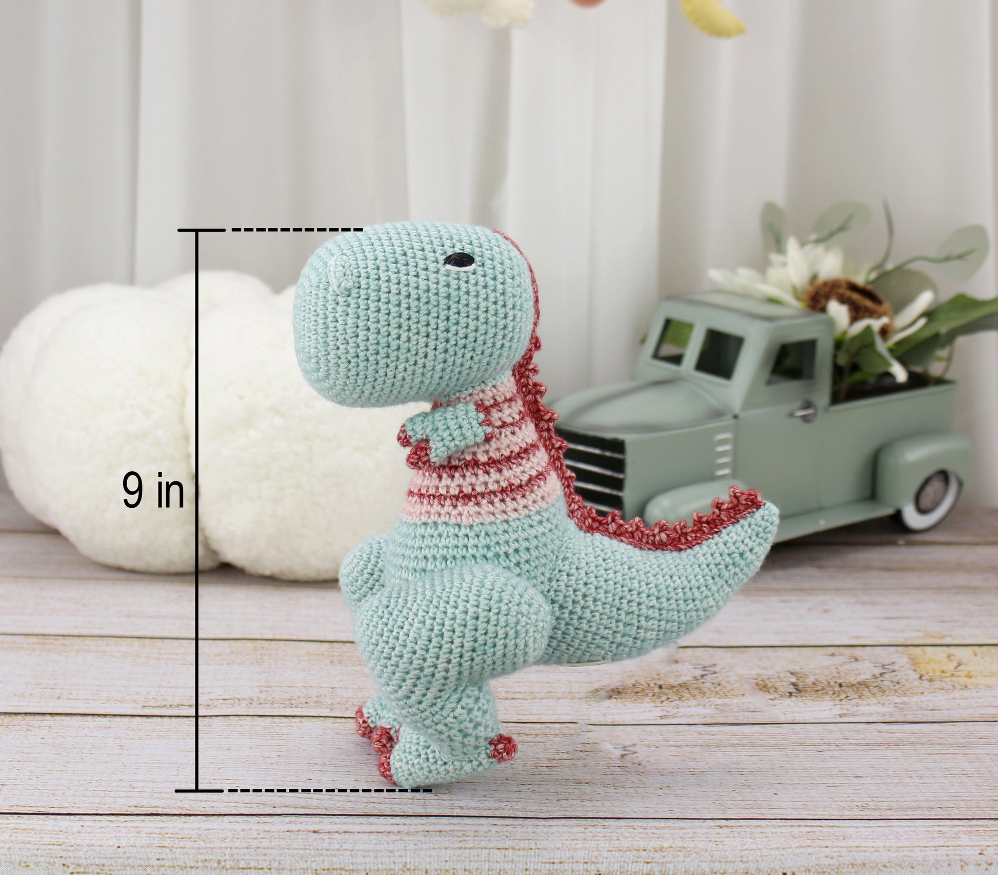 Handmade turquoise crochet T-rex plushie with red and white striped collar, 9 inches tall.