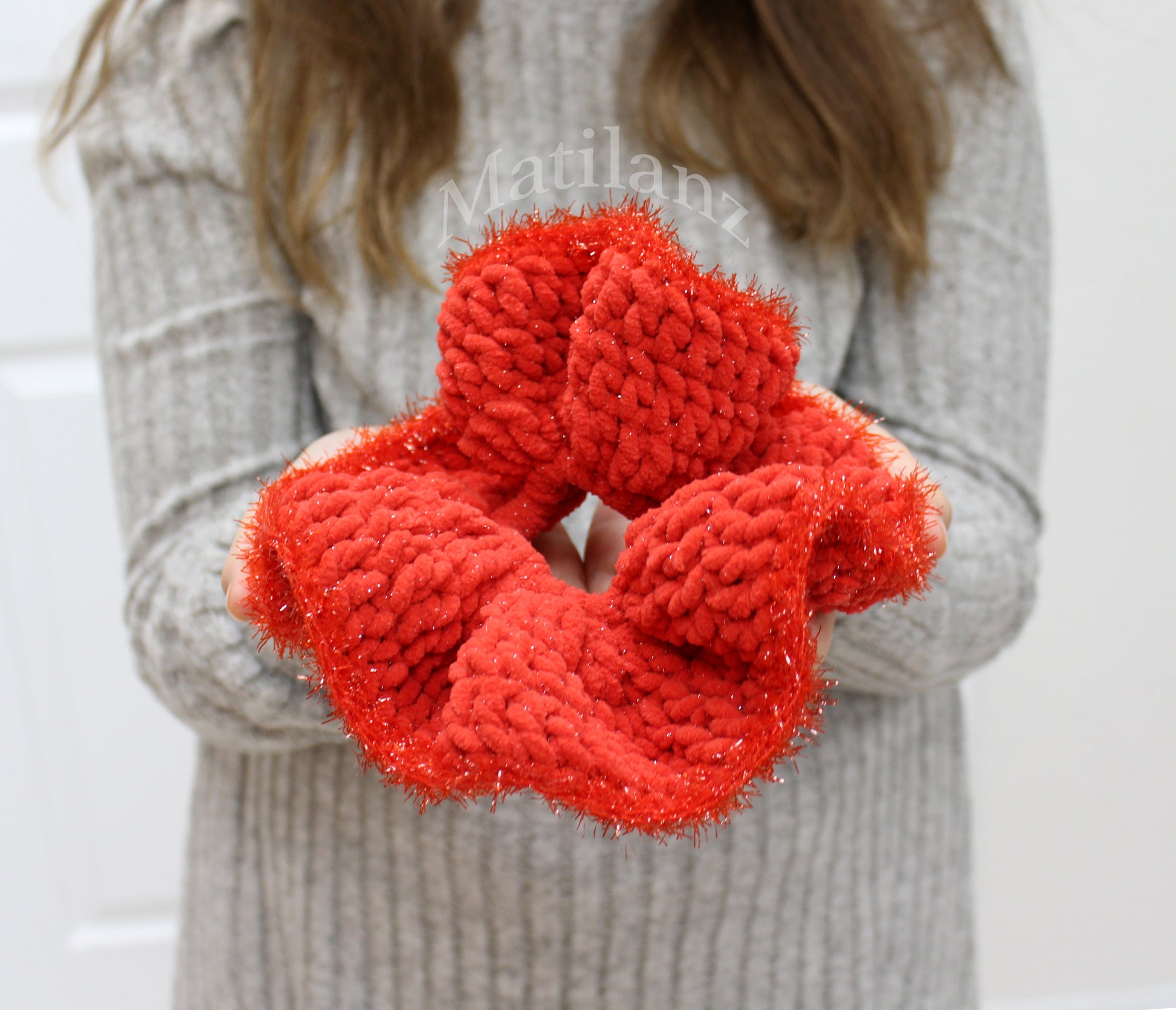 A handmade, vibrant red crochet hair scrunchie with a large elastic band for girls.