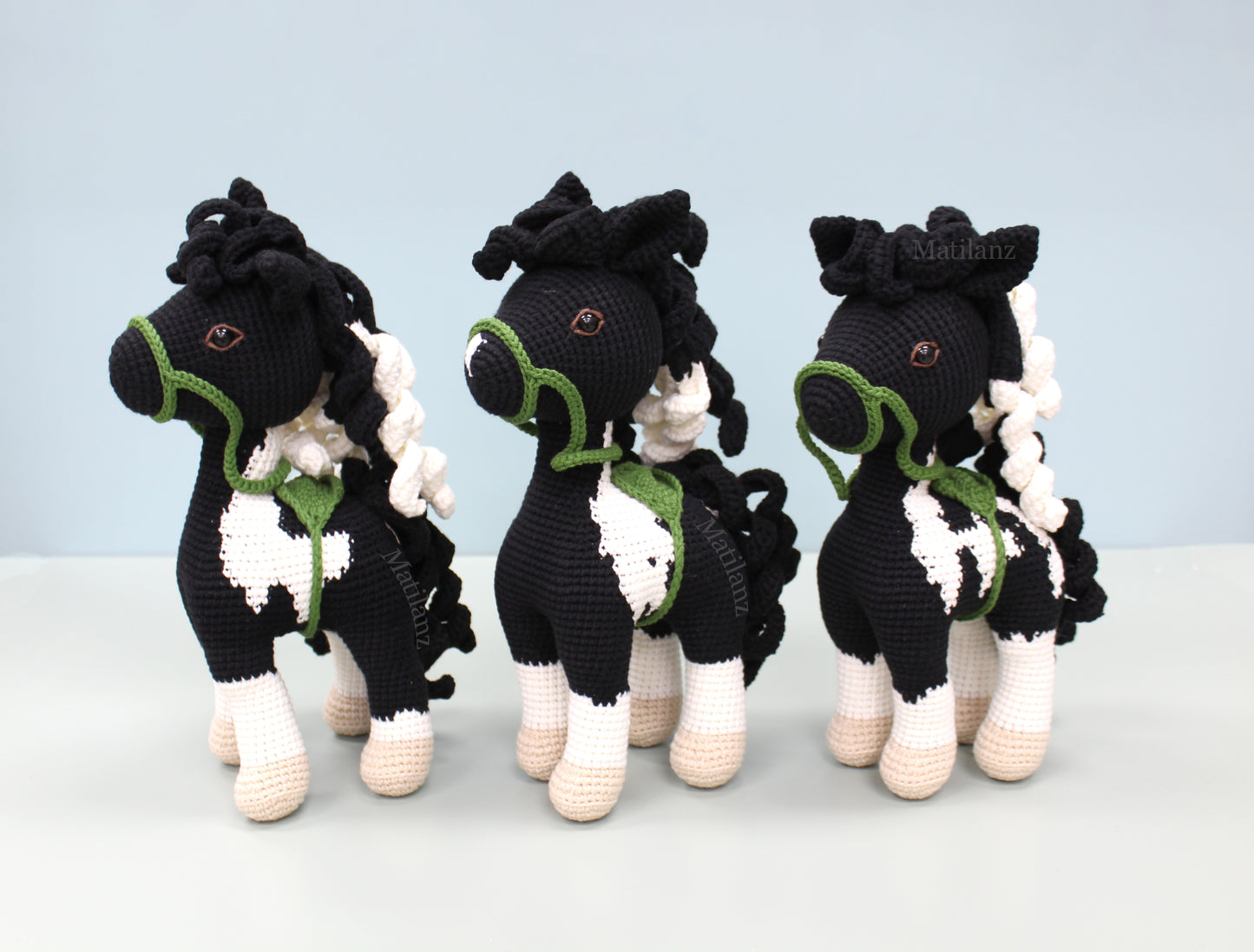 Crochet paint horse plush in black and white with green accents, handmade for a charming 11-inch toy.