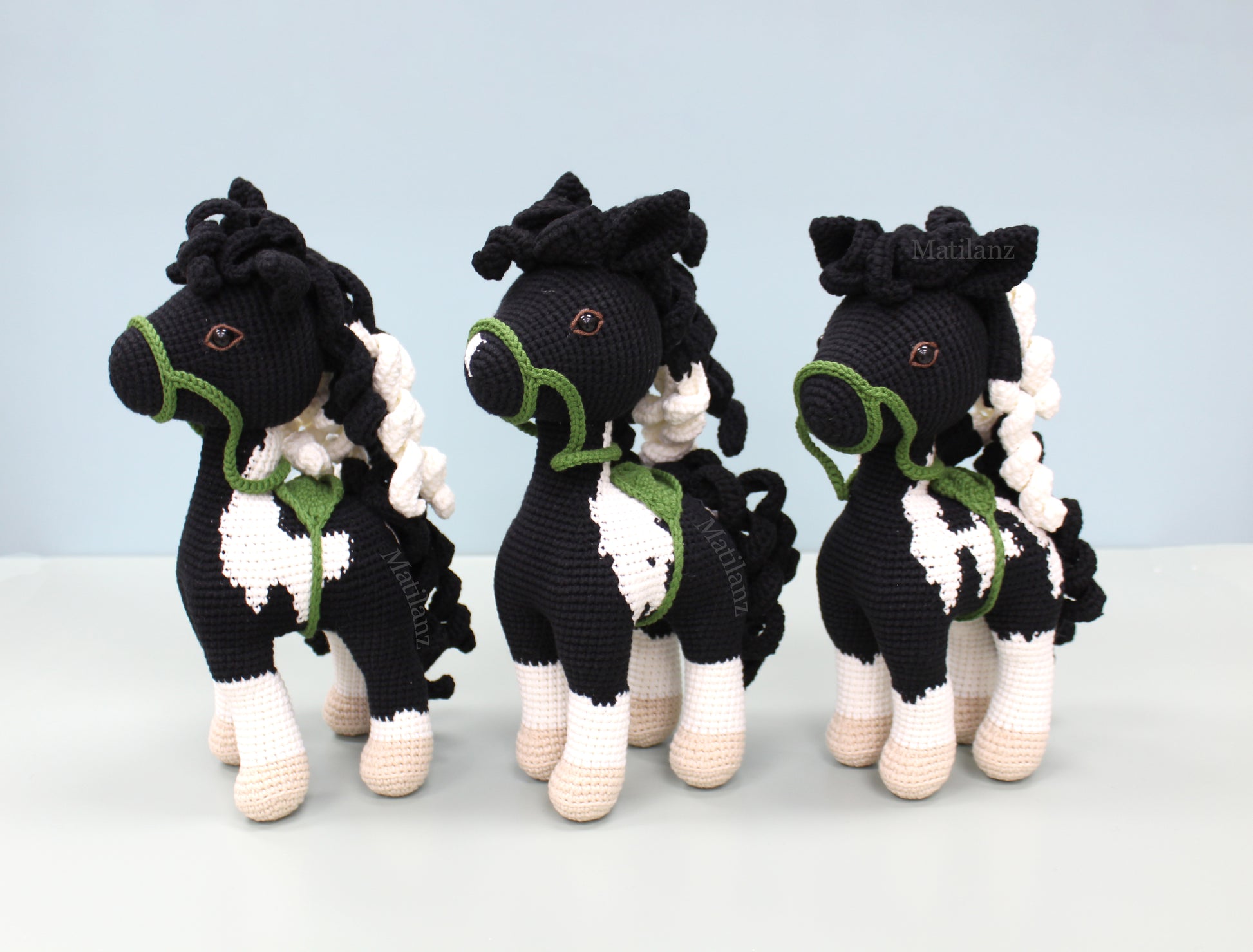 Crochet paint horse plush in black and white with green accents, handmade for a charming 11-inch toy.