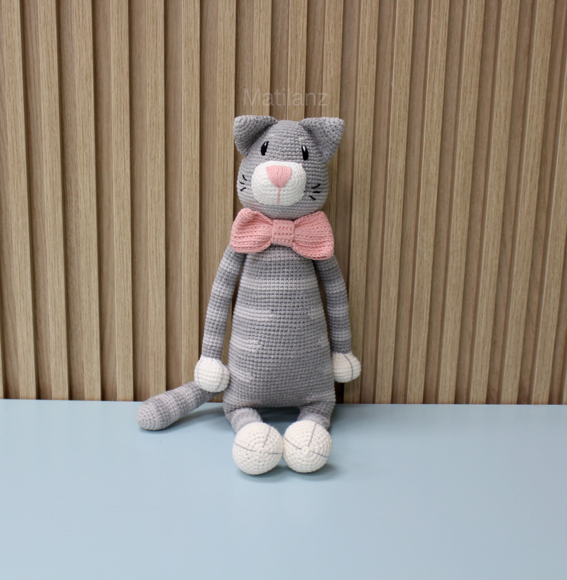 Gray amigurumi cat plush with pink bow, white accents, and 18-inch size.