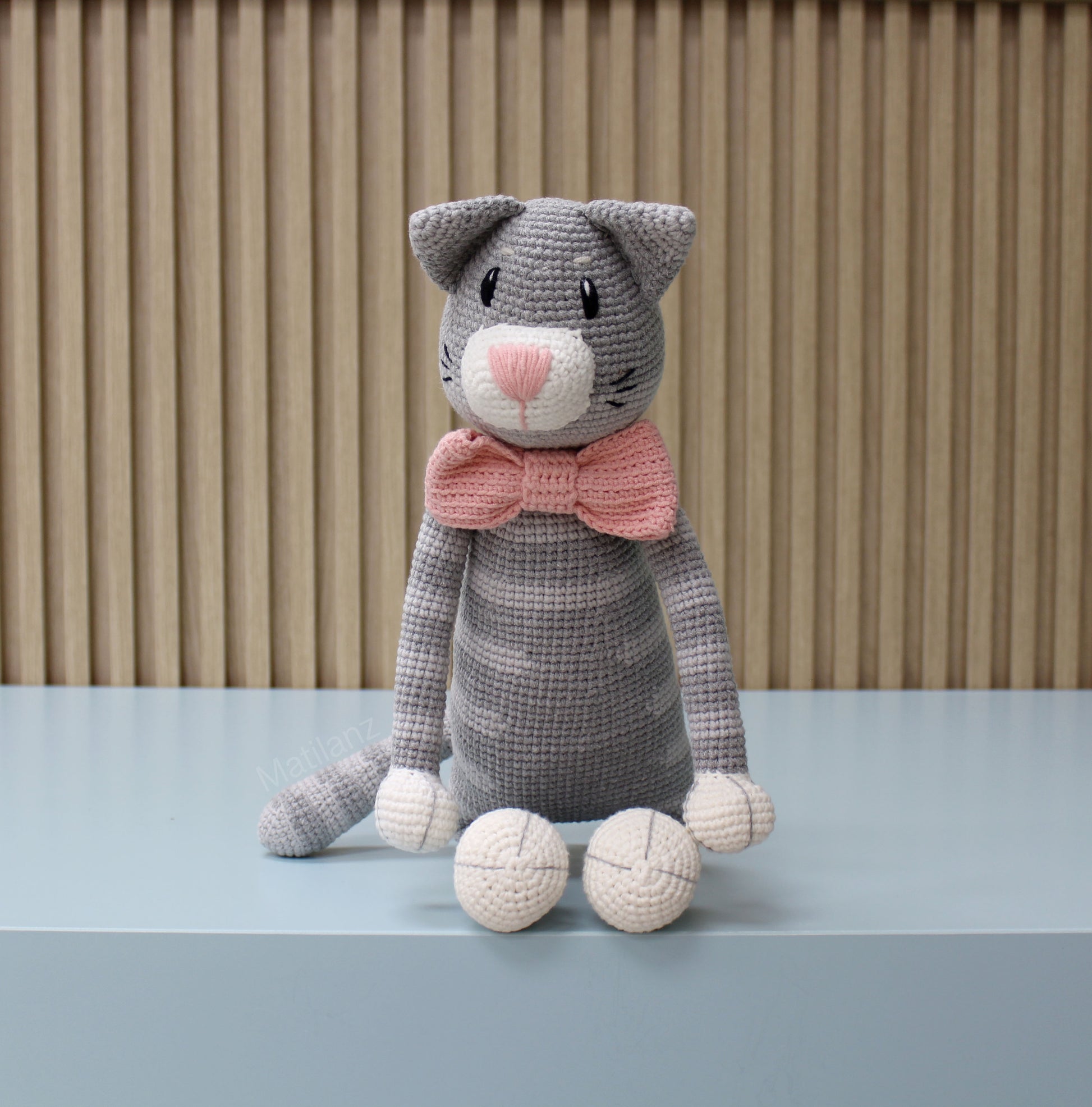 Gray amigurumi crochet cat plush with a pink bow tie, 18 inches tall.