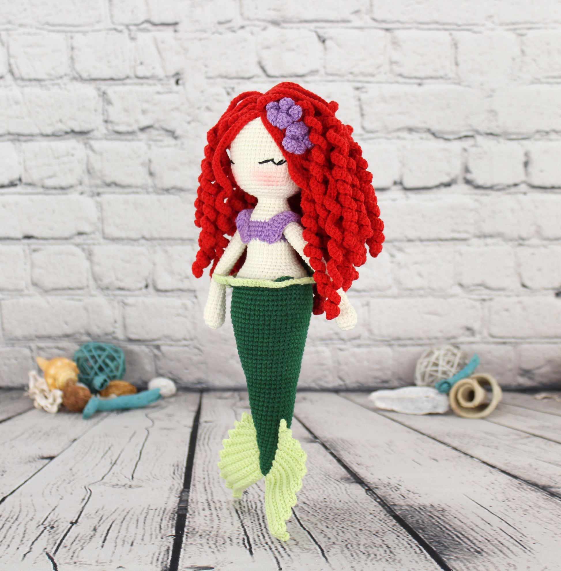 Handmade crochet mermaid doll with red hair, purple flower, green tail, and purple top.