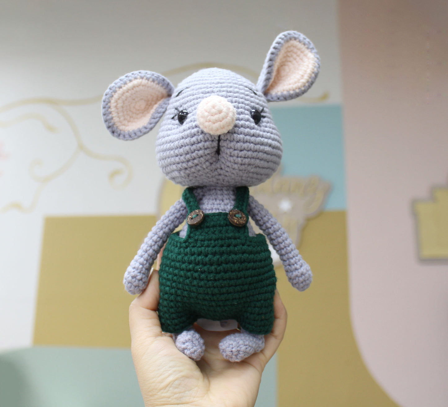 "Handmade gray mouse stuffed animal with pink nose, green overalls, and soft, cozy details."