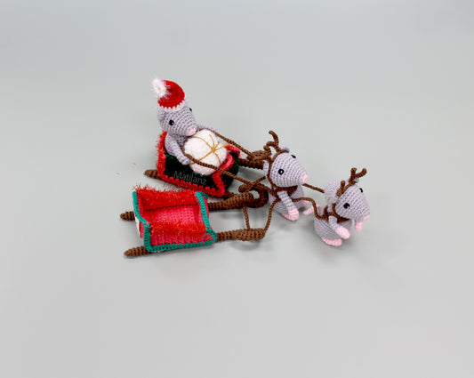 Handmade crochet Christmas mice with a sleigh, featuring festive colors and adorable details.