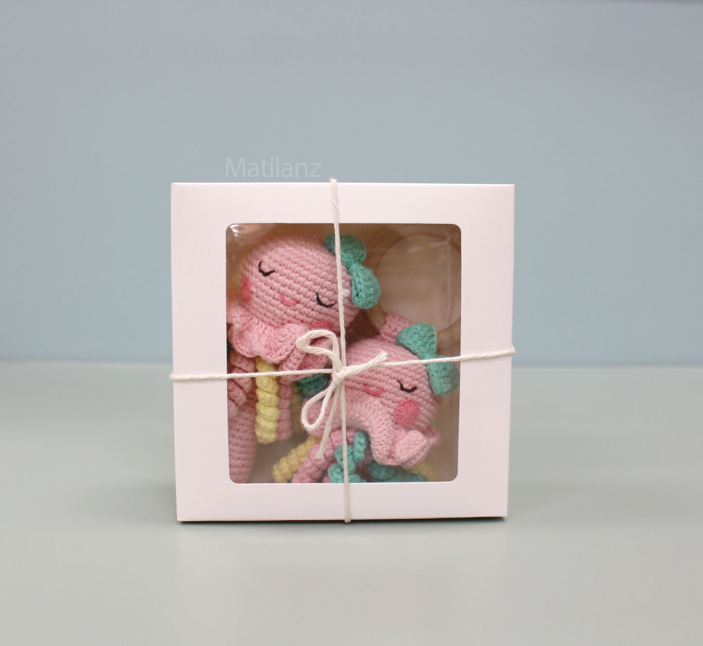 Handmade crochet jellyfish baby rattle toy set in pink and teal, made from 100% cotton.