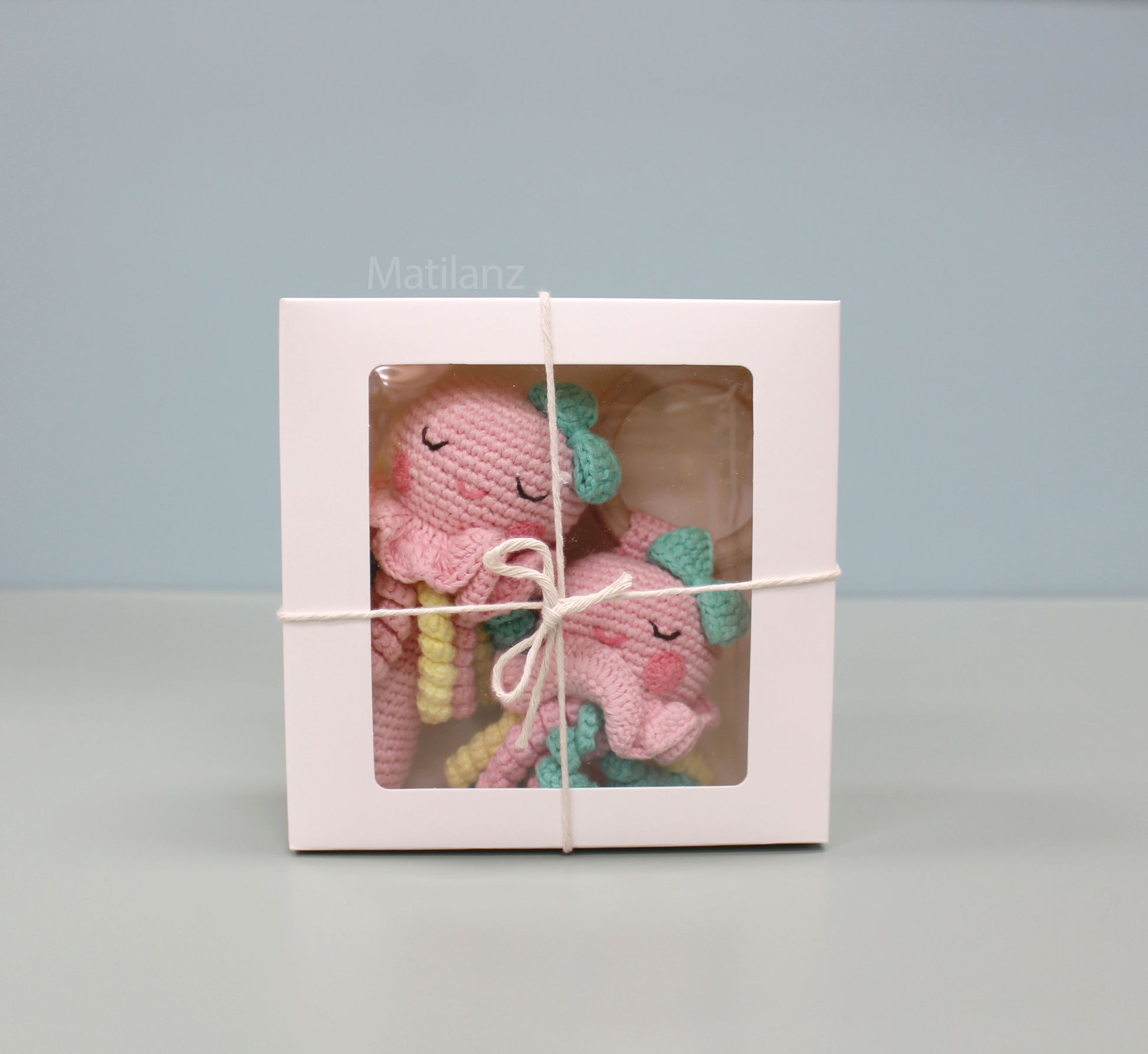 Handmade crochet jellyfish baby rattle toy set in pink and teal, made from 100% cotton.