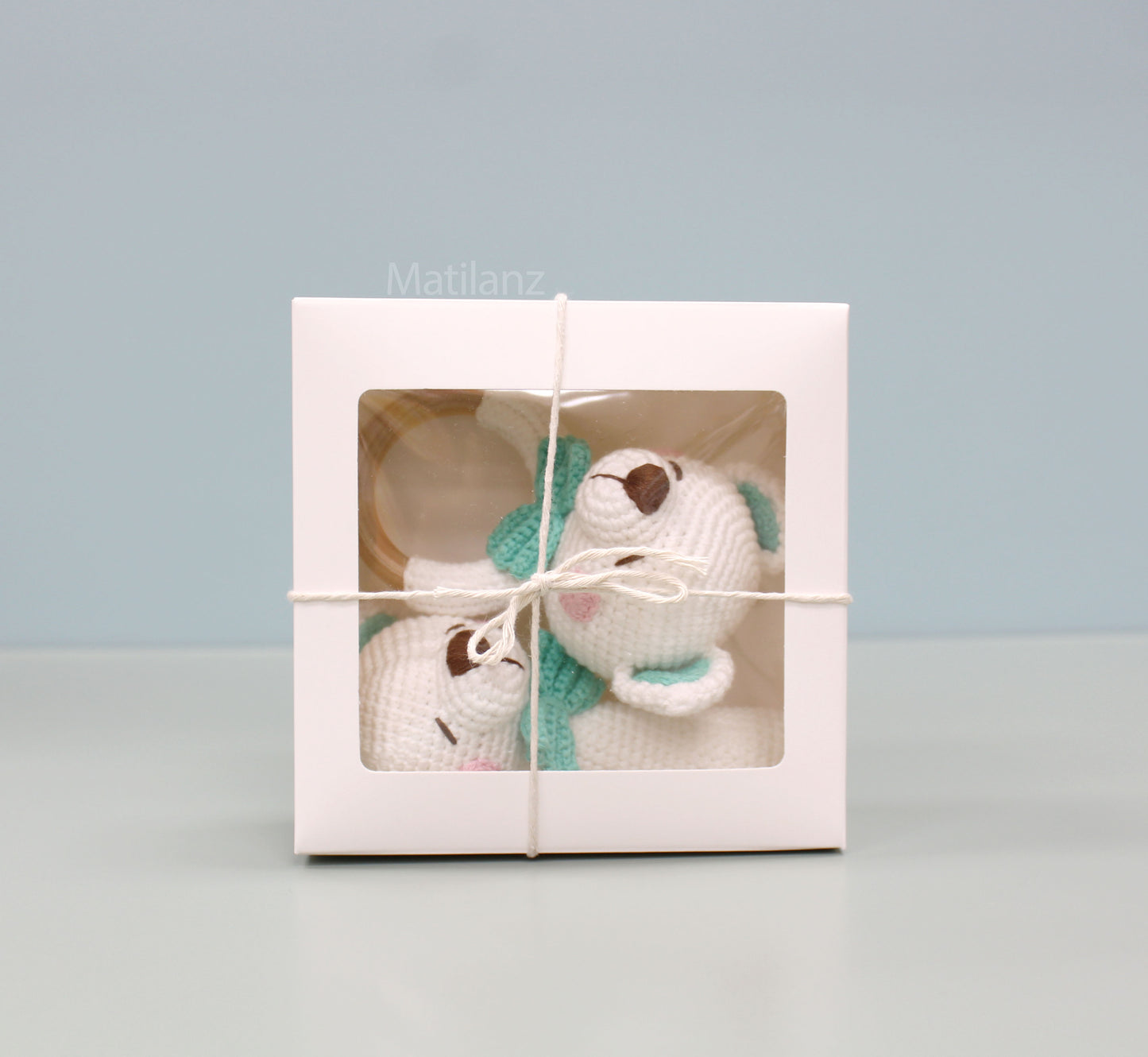 Handmade white crochet baby bear with green accents, packaged in a gift box.