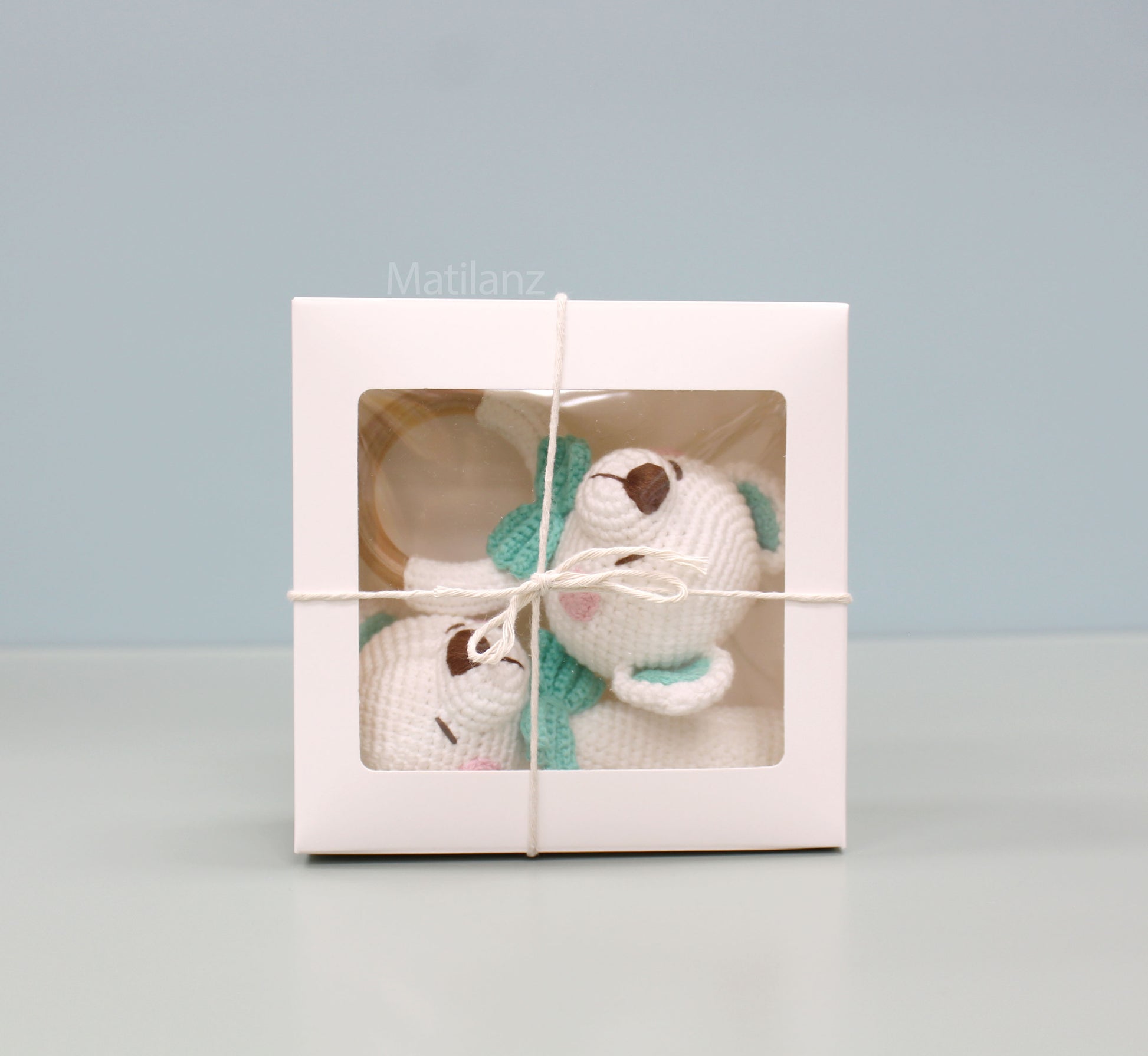 Handmade white crochet baby bear with green accents, packaged in a gift box.