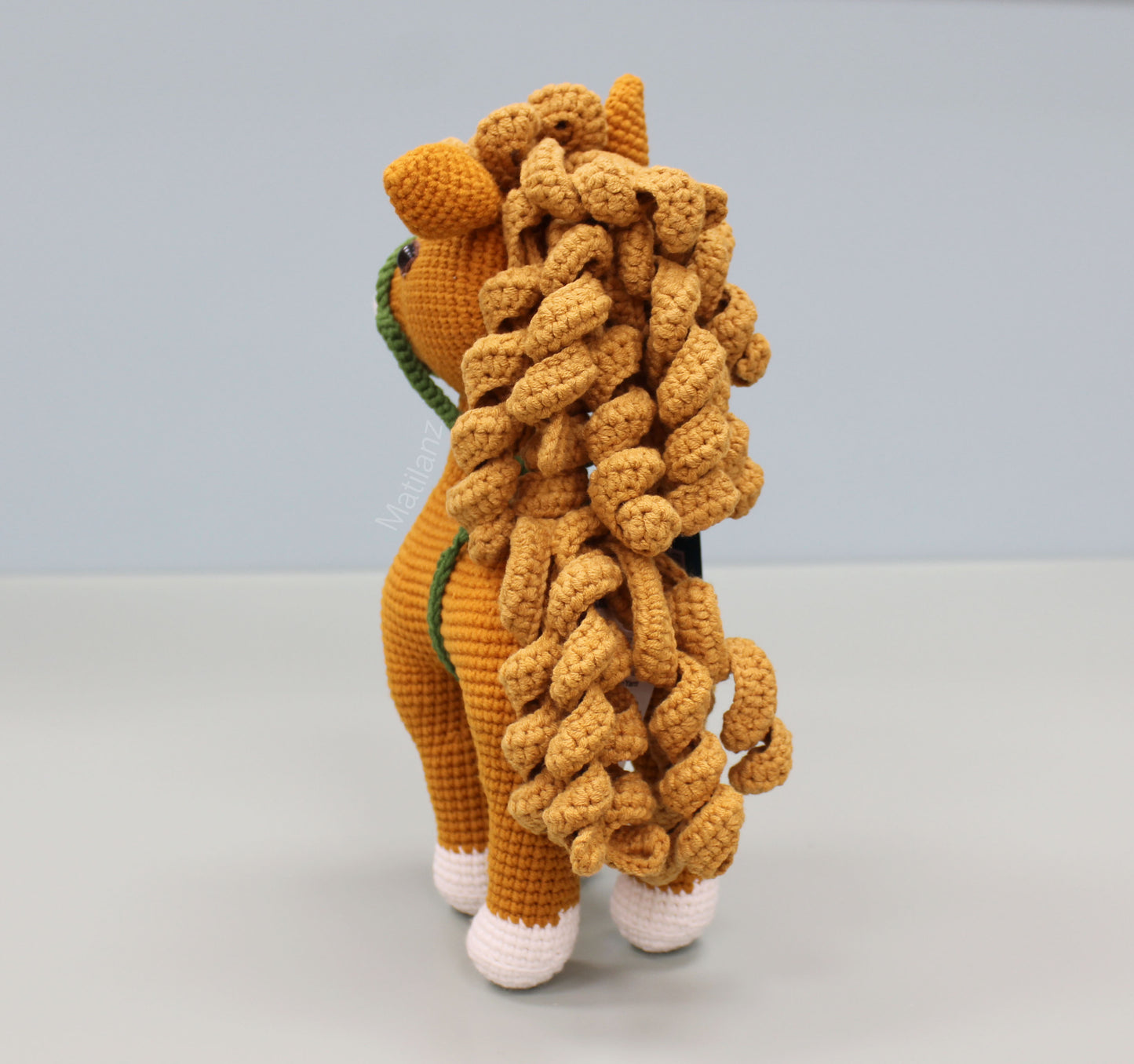 Handmade 10-inch crochet horse in copper with white feet and a textured mane.