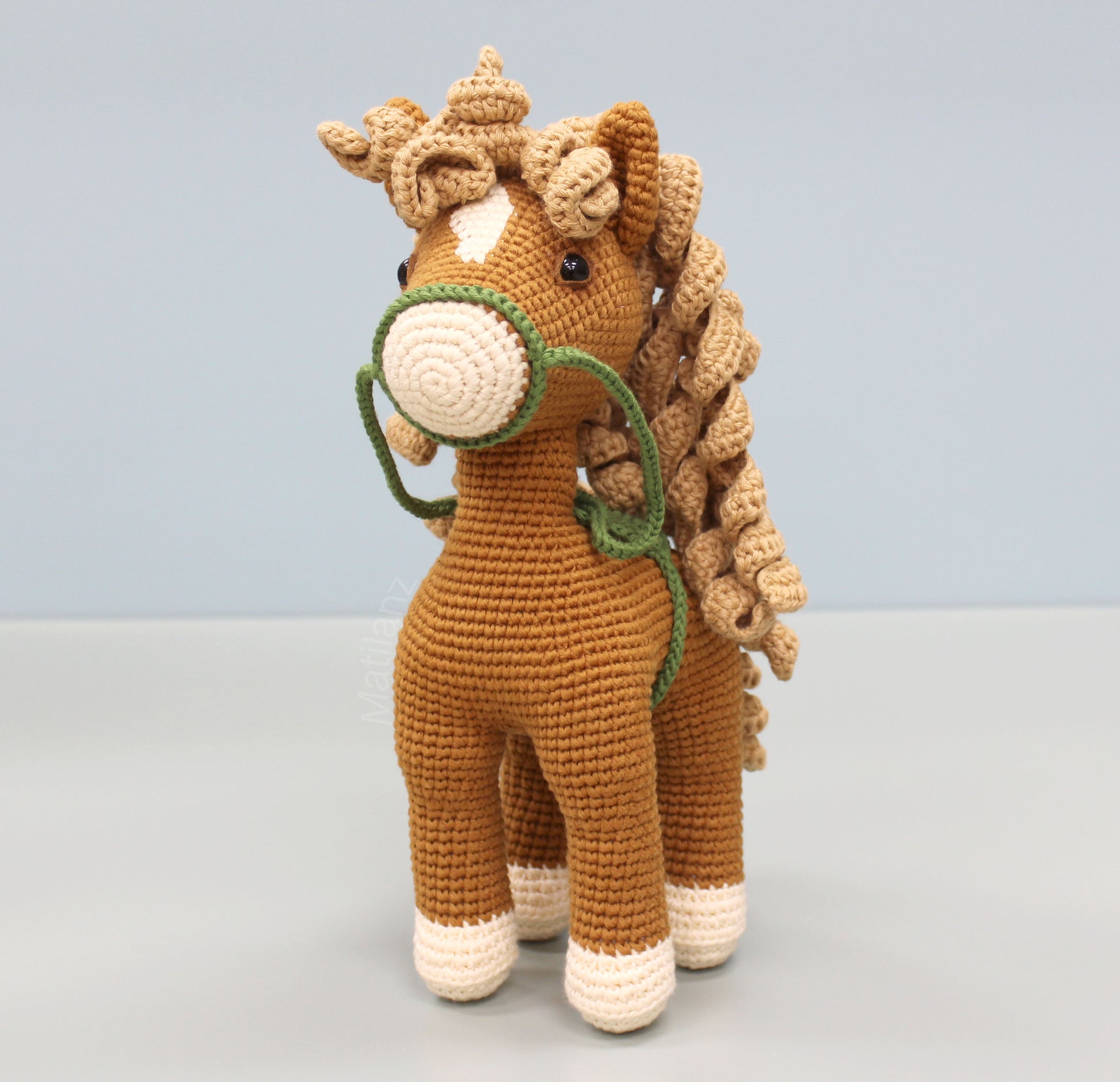 A handmade brown crochet horse soft toy, 10 inches tall, with white accents on its face and legs.