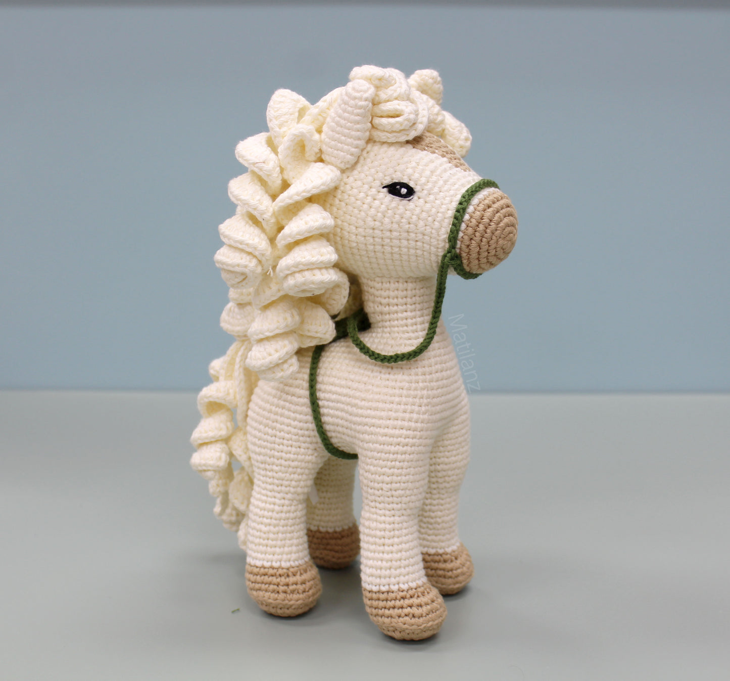 White handmade crochet horse with brown accents and flowing hair, 10 inches tall.