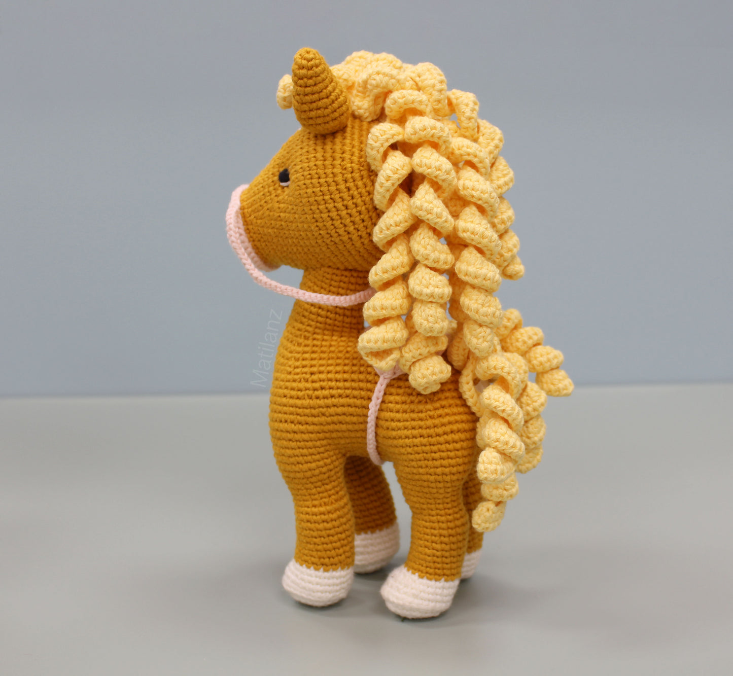 Handmade crochet horse soft toy in orange with yellow curls, white accents, and 10-inch stature.