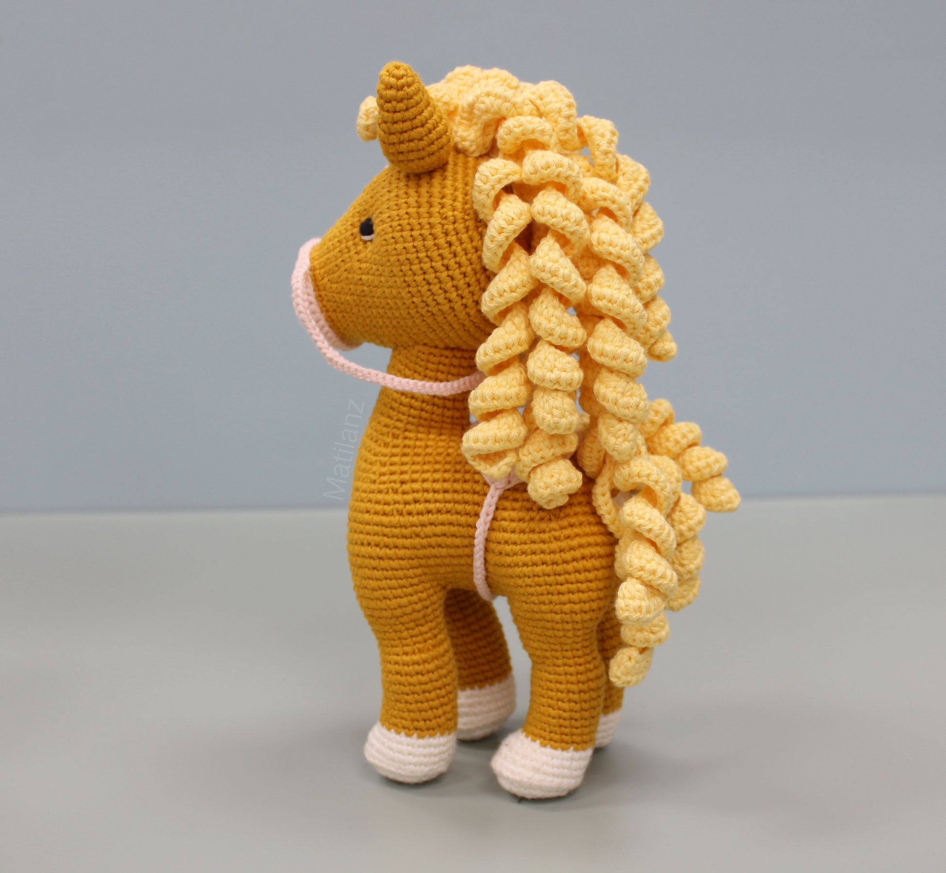 Handmade crochet horse soft toy in orange with yellow curls, white accents, and 10-inch stature.