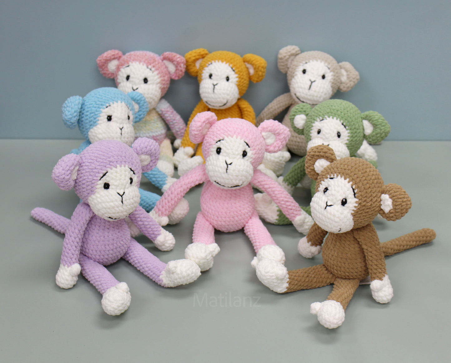 Handmade crochet monkey plush in various colors, each 11 inches tall with white accents.
