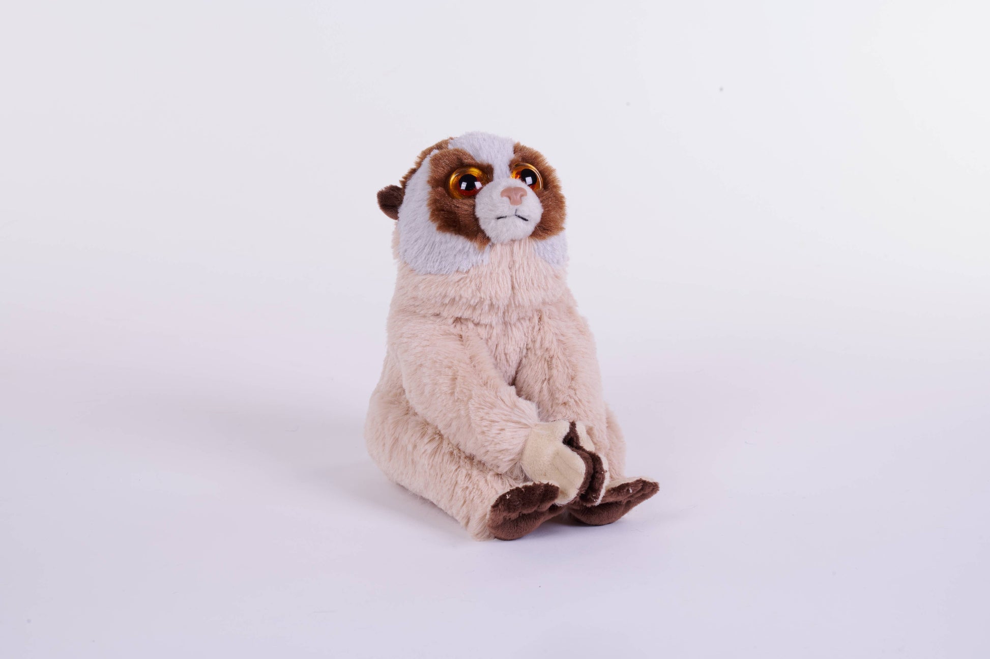 Plush slow loris toy with soft beige and brown fur, seated upright