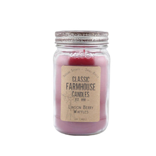 Deep red candle in a rustic mason jar with "Lingonberry Waffles" label and weathered metal lid featuring a star cutout.