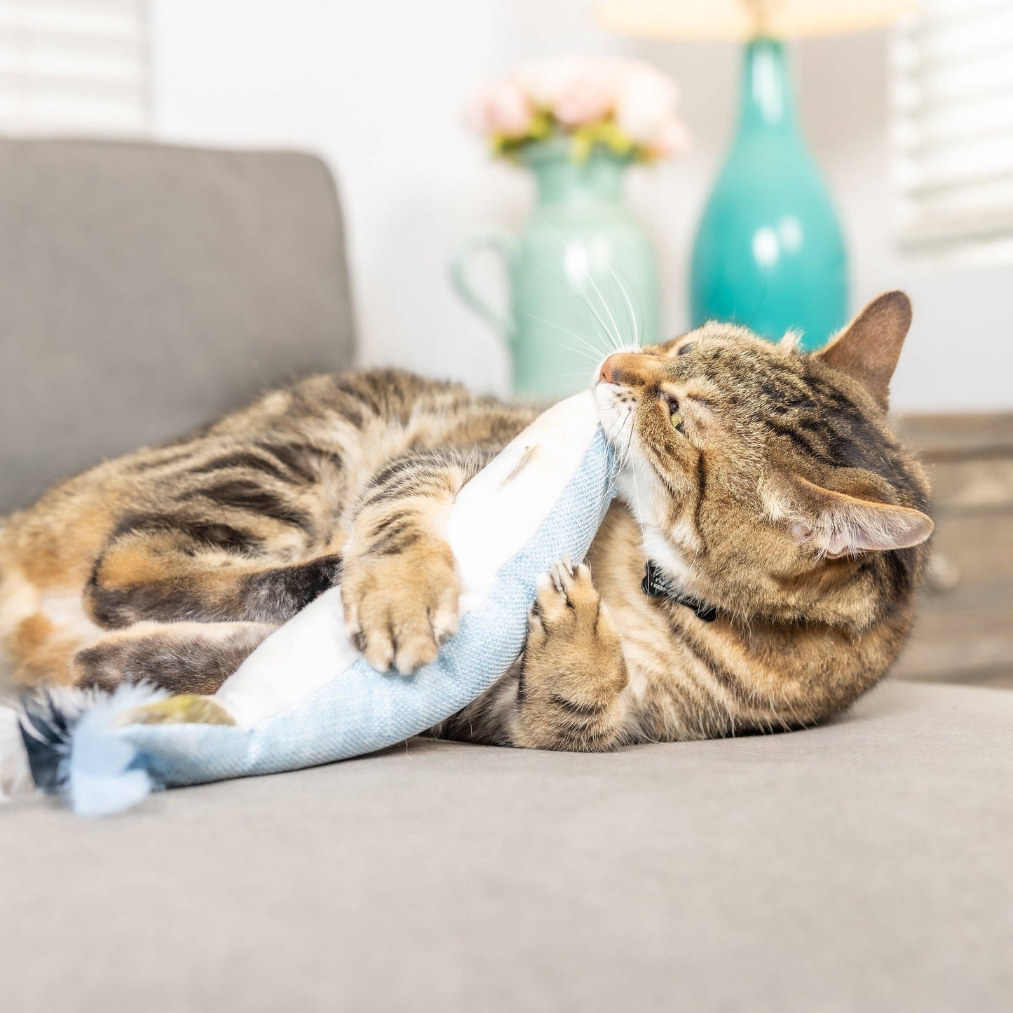 Plush blue and white fish cat toy with feathered tail, filled with catnip.