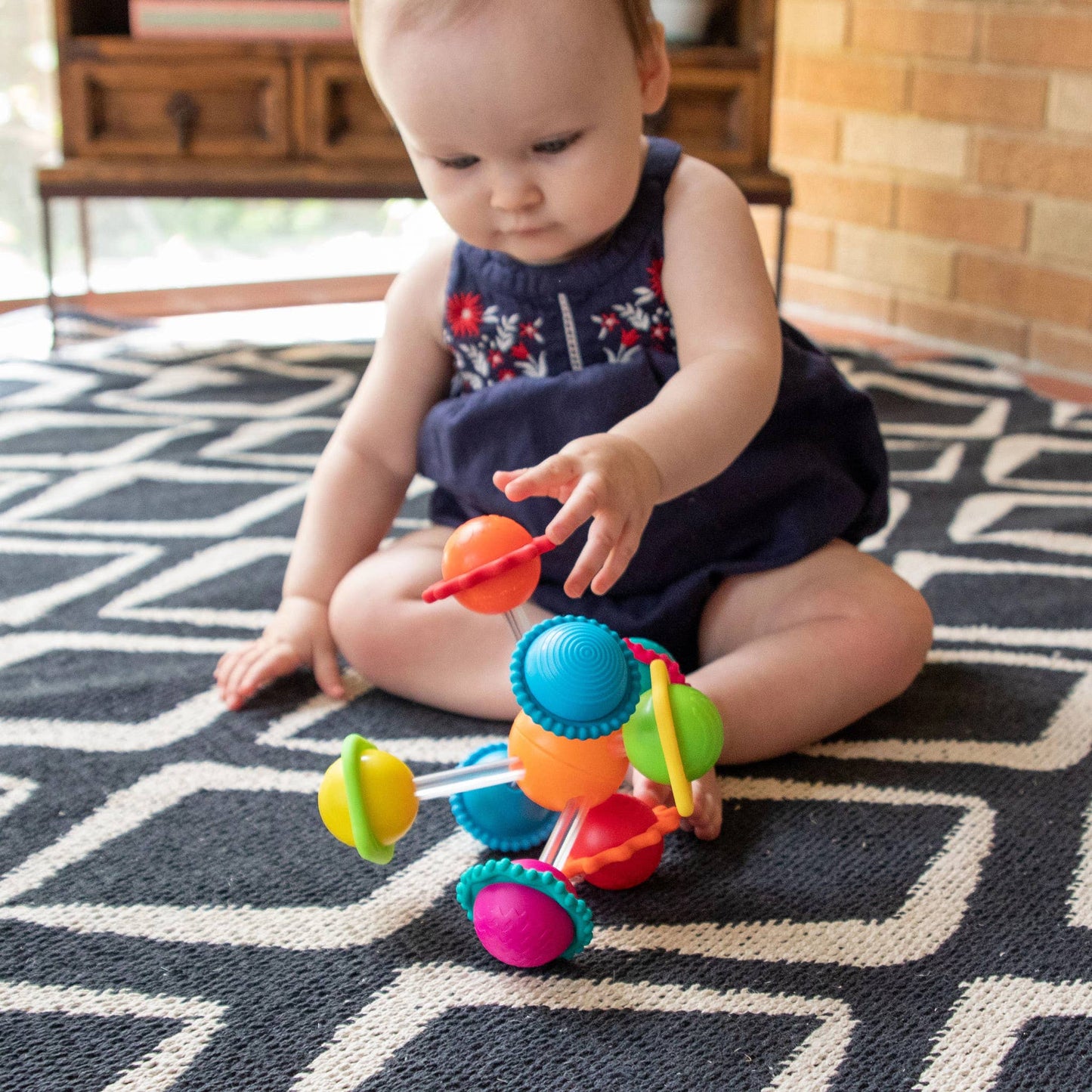 Multicolor sensory activity toy with spinning silicone rings, perfect for baby play and development.
