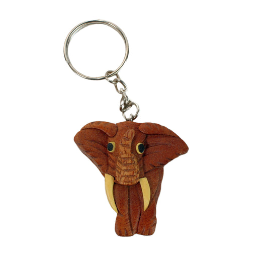 Wooden keychain featuring a carved elephant head with large tusks and wide ears, attached to a metal key ring.