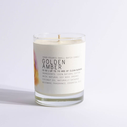 Glass candle labeled Golden Amber with creamy wax and minimalist design
