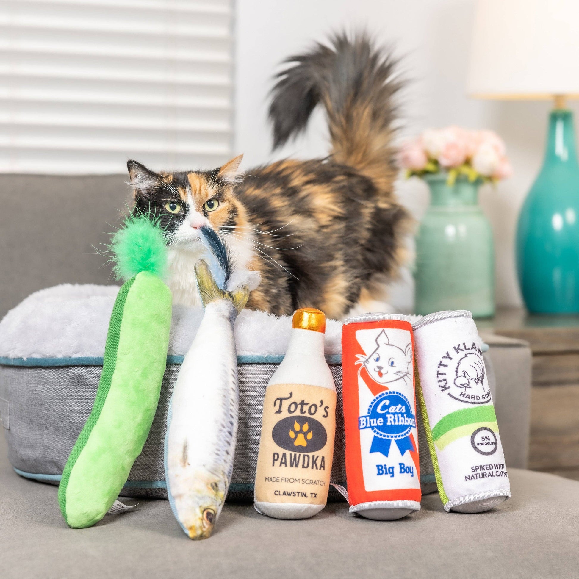 Plush cat toy set including a crinkle pickle, fish, bottle, and can, all scented with organic catnip.