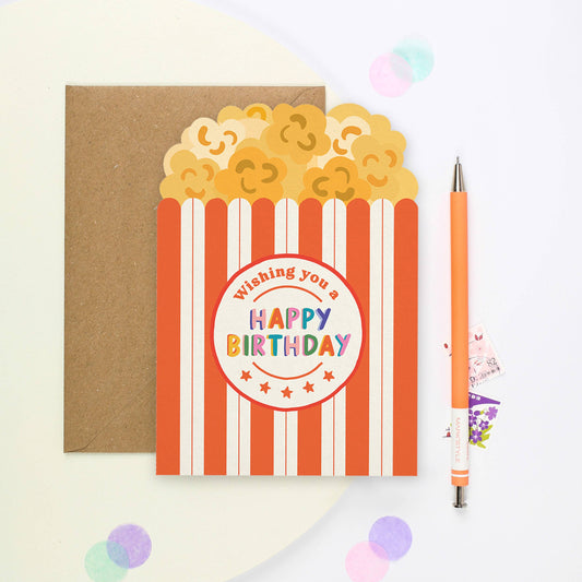 Colorful popcorn-shaped birthday card with red and white stripes and kraft envelope