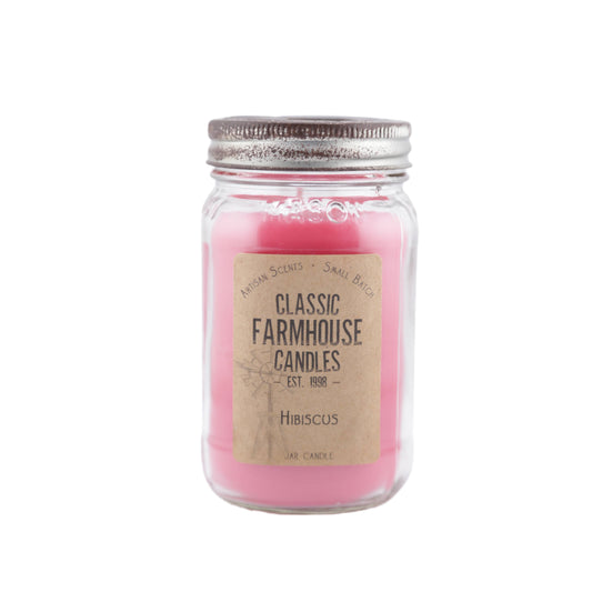 Bright pink candle in a mason jar labeled "Hibiscus" with silver farmhouse-style star lid.